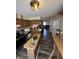 The open kitchen features wood cabinets, a kitchen island, and a view of the dining and living rooms at , Indianapolis, IN 46219