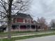 Charming two-story red home with a gray roof, a welcoming front porch, and well-maintained landscaping at 189 S Jefferson St, Martinsville, IN 46151