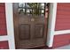 Detailed view of the wood front door, accentuating its unique design and solid construction of the red home at 189 S Jefferson St, Martinsville, IN 46151
