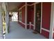 Spacious front porch showcasing a red home's exterior, providing a perfect spot for relaxing and enjoying the outdoors at 189 S Jefferson St, Martinsville, IN 46151