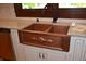 Detailed view of a copper kitchen sink with decorative accents, stone countertops, and custom white cabinets at 189 S Jefferson St, Martinsville, IN 46151