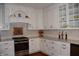 Bright kitchen with white cabinets, granite countertops, stainless steel appliances, and custom copper backsplash behind stove at 189 S Jefferson St, Martinsville, IN 46151
