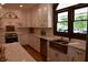 Gourmet kitchen featuring custom cabinets, stainless steel appliances, stone counter tops, and a window with backyard views at 189 S Jefferson St, Martinsville, IN 46151