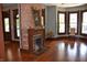 Bright living room featuring a brick fireplace, hardwood floors, and large windows for ample natural light at 189 S Jefferson St, Martinsville, IN 46151