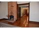 Open living area featuring hardwood floors, brick fireplace, and open doorway to kitchen at 189 S Jefferson St, Martinsville, IN 46151