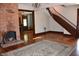 Grand living room with a brick fireplace, wooden staircase, and hardwood floors, showcasing classic design and spaciousness at 189 S Jefferson St, Martinsville, IN 46151