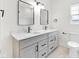 Updated bathroom with dual sinks, modern faucets, square mirrors, and a toilet with a white elongated bowl at 2031 Central Ave, Indianapolis, IN 46202