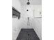 Modern shower with marbled walls, black tile floor, black fixtures and glass partition at 2031 Central Ave, Indianapolis, IN 46202