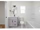 Clean bathroom featuring a shower-tub, toilet, and gray vanity with dark fixtures at 2031 Central Ave, Indianapolis, IN 46202