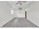 This is a spacious bedroom with neutral walls, gray carpet, a ceiling fan and a dark wooden door at 2031 Central Ave, Indianapolis, IN 46202