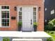 Charming brick home featuring a front door with sidelights and decorative plants at 2031 Central Ave, Indianapolis, IN 46202