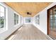 Light-filled sunroom with beamed ceiling, wood flooring, and windows at 2031 Central Ave, Indianapolis, IN 46202