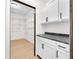 Open walk-in closet featuring granite counters, white cabinets, and wood floors at 2031 Central Ave, Indianapolis, IN 46202