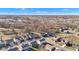 An aerial view of a neighborhood with various home styles, winding roads, and patches of natural woodland under a clear, sunny sky at 281 Dovetree Dr, Danville, IN 46122