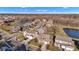 Aerial view of a residential community showcasing well-kept homes, green spaces, and a serene pond under a bright, clear sky at 281 Dovetree Dr, Danville, IN 46122