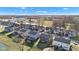 An aerial view captures a residential neighborhood featuring manicured lawns, a serene pond, and modern homes under a clear blue sky at 281 Dovetree Dr, Danville, IN 46122