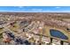 Scenic aerial view of a residential area featuring single-Gathering homes, winding streets, and a tranquil pond under a blue sky at 281 Dovetree Dr, Danville, IN 46122
