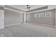 Light filled bedroom with neutral paint, carpet, tray ceiling, fan, and bright windows at 281 Dovetree Dr, Danville, IN 46122