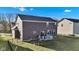 Rear exterior view of the home, highlighting the spacious backyard with a small deck, fire pit, and fence at 281 Dovetree Dr, Danville, IN 46122