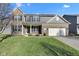 Charming two-story brick home with a well-manicured lawn and attached two-car garage on a sunny day at 281 Dovetree Dr, Danville, IN 46122