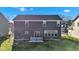 Rear exterior view of the home, highlighting the spacious backyard with a small deck, fire pit, and fence at 281 Dovetree Dr, Danville, IN 46122