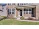 Charming front entrance with a brick facade, black door, well-manicured lawn, and blossoming landscaping at 281 Dovetree Dr, Danville, IN 46122