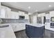 Modern kitchen featuring white cabinets, gray backsplash, and a navy blue island with quartz countertop at 281 Dovetree Dr, Danville, IN 46122