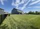 Expansive backyard features a well-manicured lawn, black fence, and a patio with outdoor furniture for entertaining at 3535 Merchmont Rd, Bargersville, IN 46106