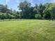 Serene backyard view showcases a lush green lawn, privacy fence, and mature trees, providing a private oasis at 3535 Merchmont Rd, Bargersville, IN 46106