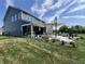 Spacious backyard featuring a patio, outdoor kitchen, dining area with umbrella, and fire pit seating for relaxing entertainment at 3535 Merchmont Rd, Bargersville, IN 46106