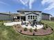 Spacious backyard boasts a patio with a fire pit, seating, landscaping and outdoor dining under a large umbrella at 3535 Merchmont Rd, Bargersville, IN 46106