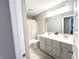 Neutral bathroom boasts double sinks, quartz countertops, and a large mirror above the vanity at 3535 Merchmont Rd, Bargersville, IN 46106
