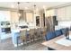 Spacious kitchen with white cabinets, stainless steel appliances, a large island, and an open view to the dining area at 3535 Merchmont Rd, Bargersville, IN 46106