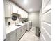 Well-lit laundry room features white cabinetry, a stainless steel trashcan, a modern sink and a washer and dryer at 3535 Merchmont Rd, Bargersville, IN 46106