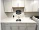 Laundry room boasts a spacious countertop, sink, upper cabinets, and self-service laundry signage for added convenience at 3535 Merchmont Rd, Bargersville, IN 46106