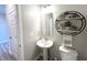 Cozy powder room with pedestal sink, decorative shelving, and wall-mounted mirror at 3535 Merchmont Rd, Bargersville, IN 46106