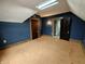 Attic bedroom features a blue wallpaper, skylight, and a wooden door at 367 W Broadway St, Shelbyville, IN 46176