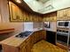 Eat-in kitchen with updated oven and range, wood cabinets, and pot rack at 367 W Broadway St, Shelbyville, IN 46176