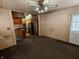 Open living area with dark carpet, painted wood walls, and kitchen access at 367 W Broadway St, Shelbyville, IN 46176