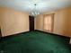 Living room featuring green carpet, vintage wooden trim, neutral walls and chandelier at 367 W Broadway St, Shelbyville, IN 46176