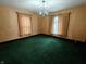Living room featuring green carpet, neutral walls, chandelier, and curtained windows at 367 W Broadway St, Shelbyville, IN 46176