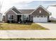 Charming brick home featuring a two-car garage, manicured lawn, and inviting curb appeal at 3865 Kensington Dr, Danville, IN 46122