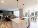 Open eat-in kitchen overlooking the living and dining areas, featuring an island with seating and stainless appliances at 3865 Kensington Dr, Danville, IN 46122