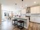 Bright eat-in kitchen featuring an island with seating, modern lighting, stainless appliances, and ample cabinet space at 3865 Kensington Dr, Danville, IN 46122