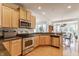 Open kitchen with stainless steel appliances and granite countertops flowing into a sunny living area at 405 Letterman Dr, Brownsburg, IN 46112