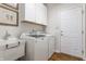 Bright laundry room with a utility sink, modern washer and dryer, white cabinets, and wood-look flooring at 405 Letterman Dr, Brownsburg, IN 46112