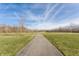 Inviting walking path winding through lush green spaces under a beautiful blue sky at 405 Letterman Dr, Brownsburg, IN 46112