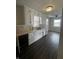 This kitchen features matching white cabinets, hard surface floors, and natural light from the windows at 447 S Bradley Ave, Indianapolis, IN 46201