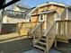 View of the back of the home with a spacious deck, stairs, and backyard at 4504 Winthrop Ave, Indianapolis, IN 46205