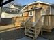 View of the back of the home with a spacious deck, stairs, and backyard at 4504 Winthrop Ave, Indianapolis, IN 46205